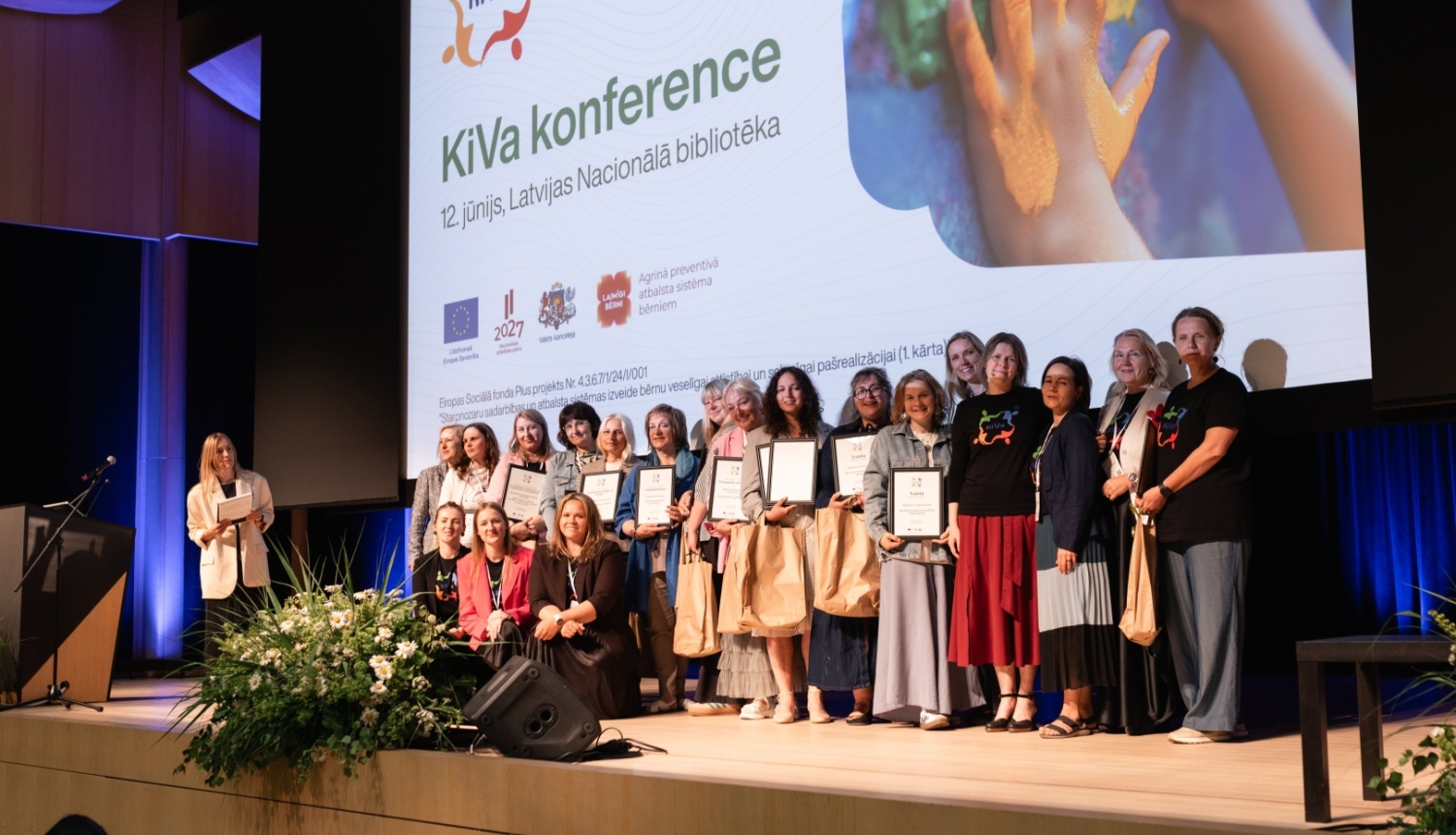 konferences dalībnieki ar diplomiem uz skatuves